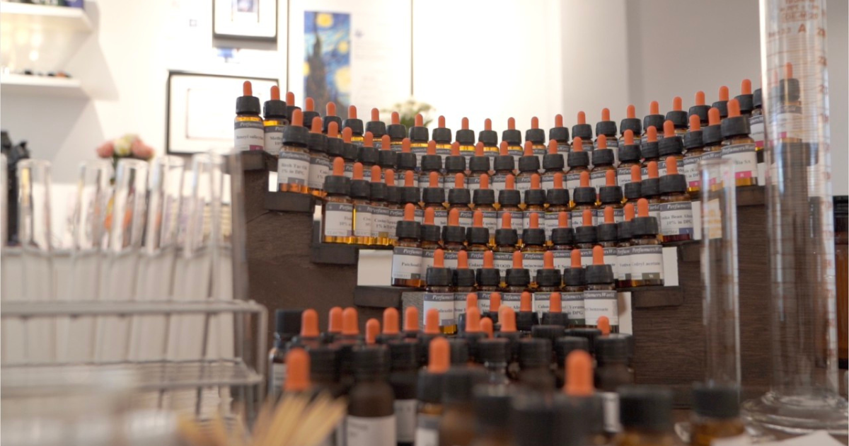 An organised working collection of fragrance materials in small amber bottles
